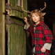 Deer child Gus (Christian Convery) peers out a barn door in Netflix's Sweet Tooth.